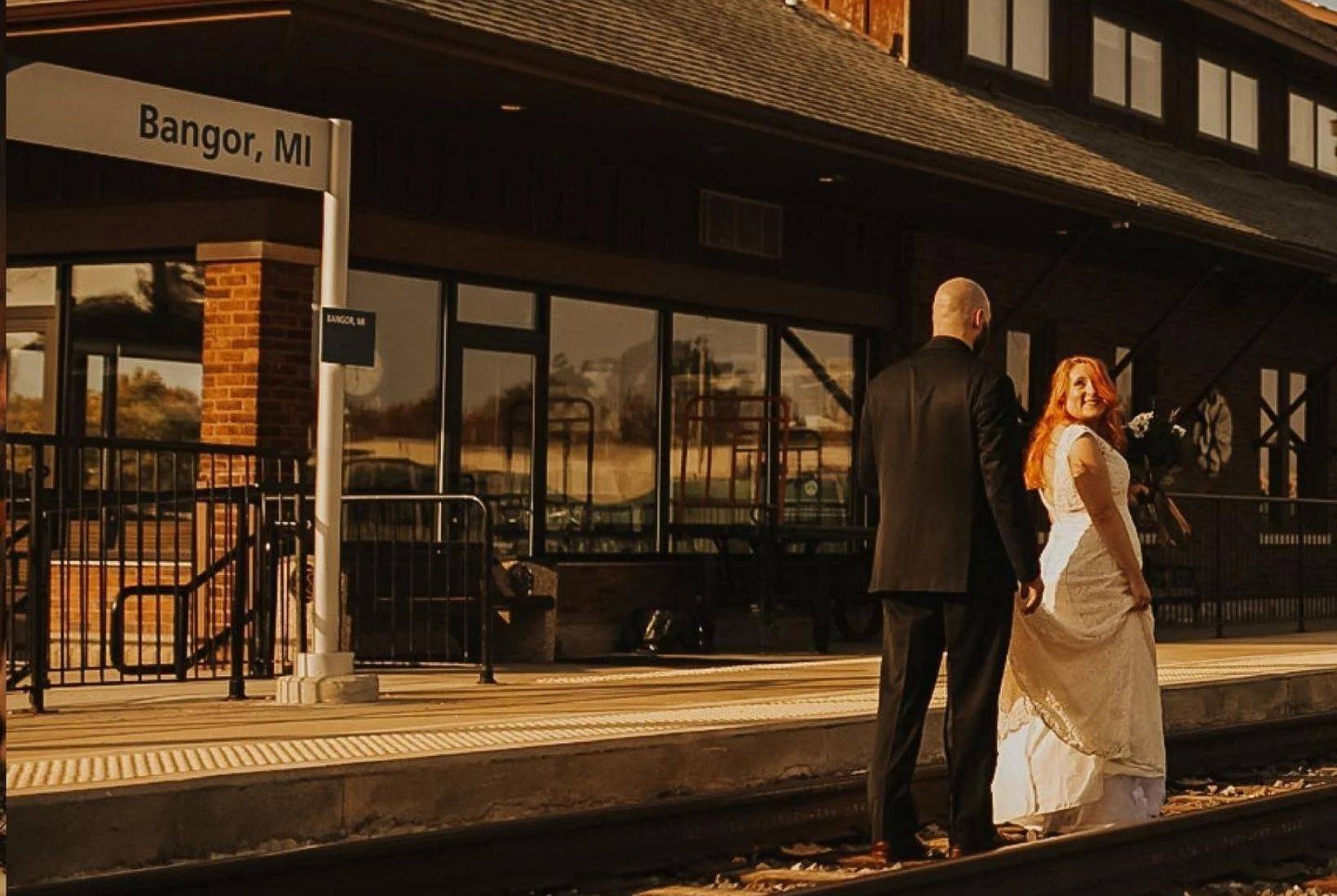 Bride and groom walking along the train tracks at the Bangor, MI station for Bangor Michigan weddings.