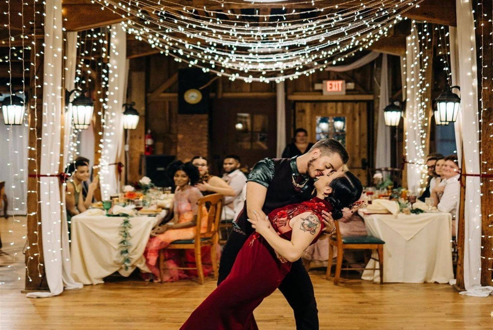 Couple dancing beneath glowing string lights at Mill Hall wedding venue in South Haven.