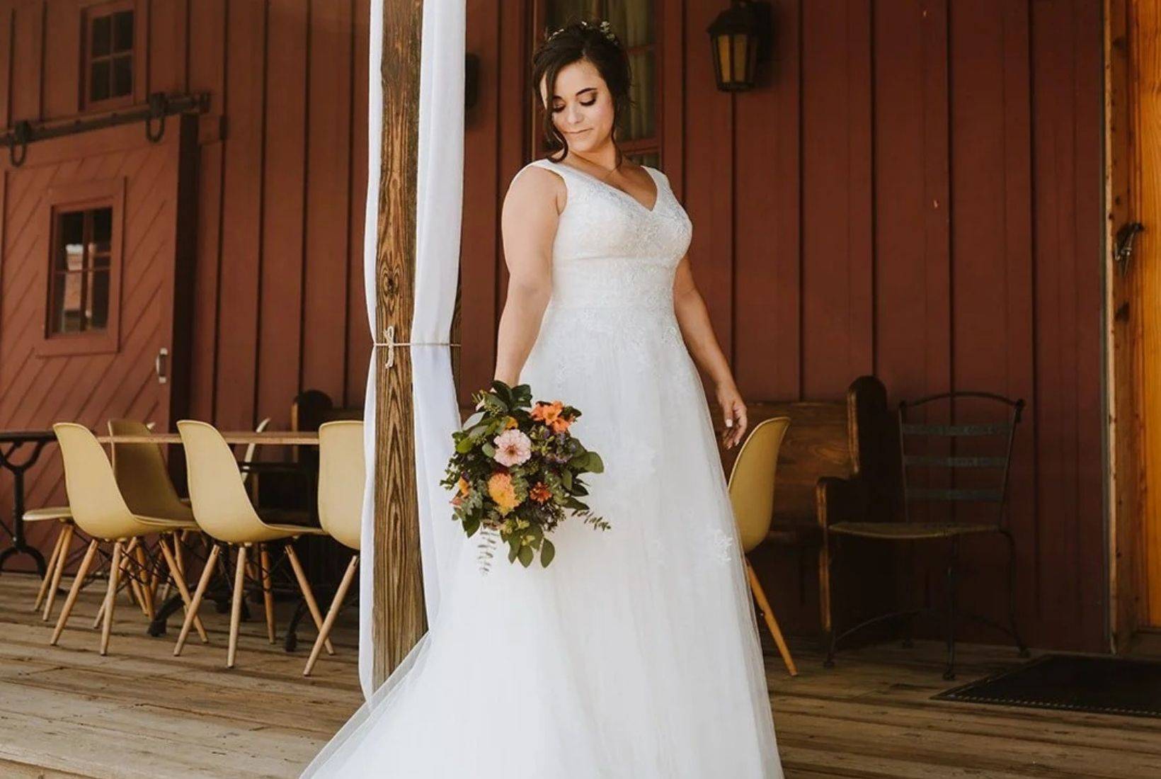 Bride holding bouquet at rustic Michigan wedding venue with outdoor ceremony setting